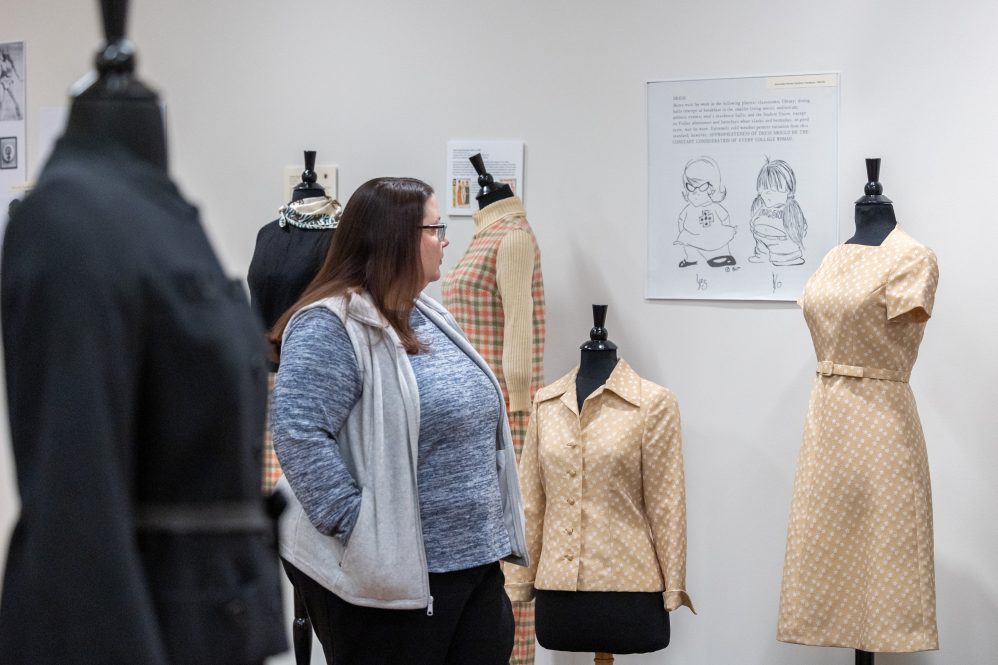 woman looking at an exhibit of vintage clothing