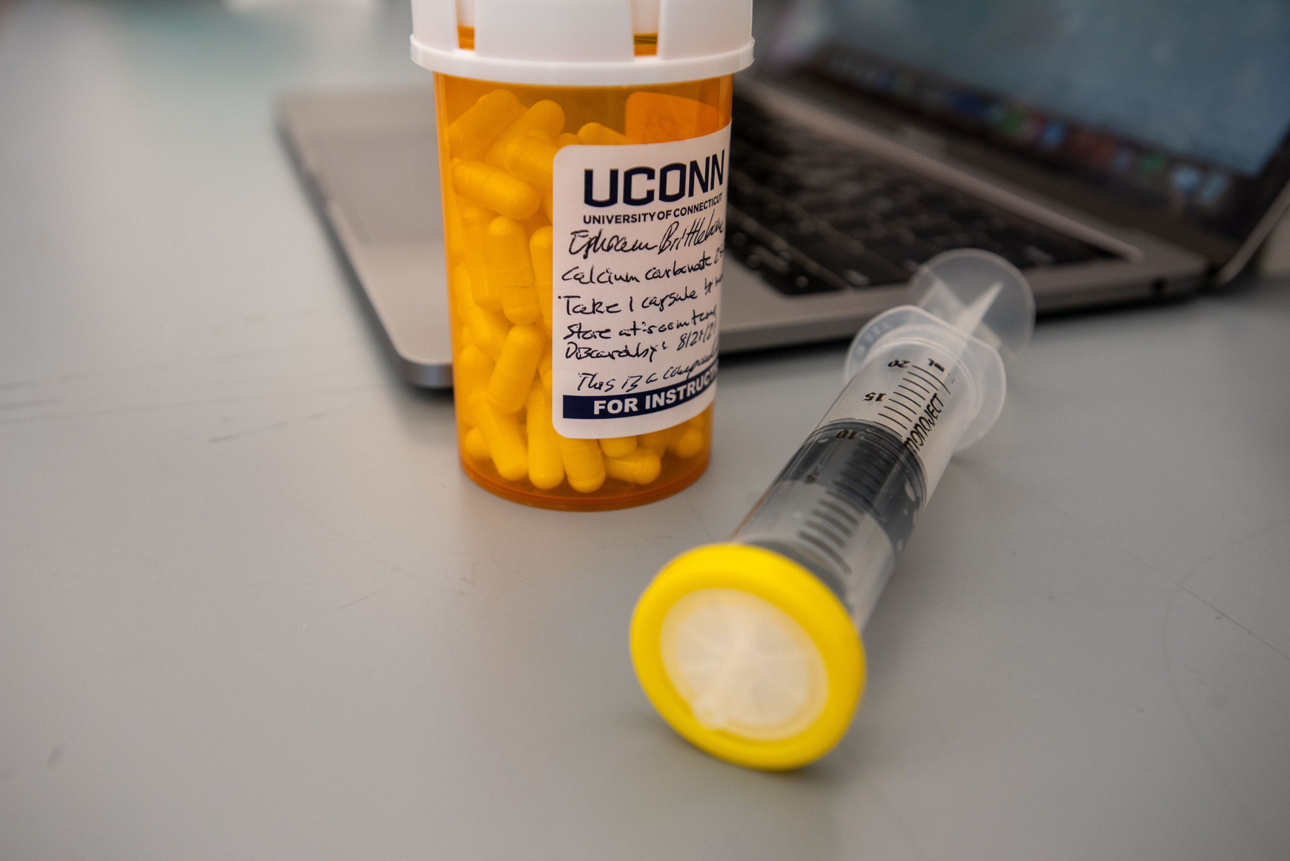 Medication, syringe, and laptop at the School of Pharmacy on  March 10, 2021. (Sean Flynn/UConn Photo)